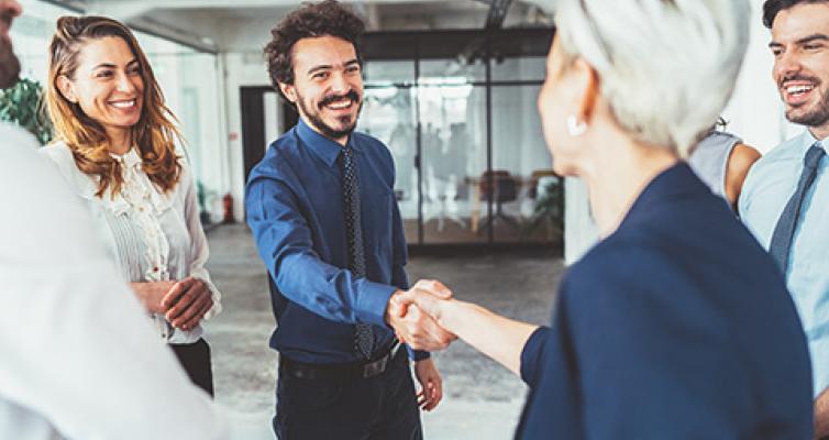 Zwei Menschen geben sich die Hand.