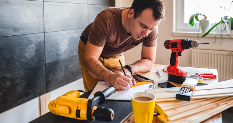 Mann beim ausmessen von Holzzuschnitten