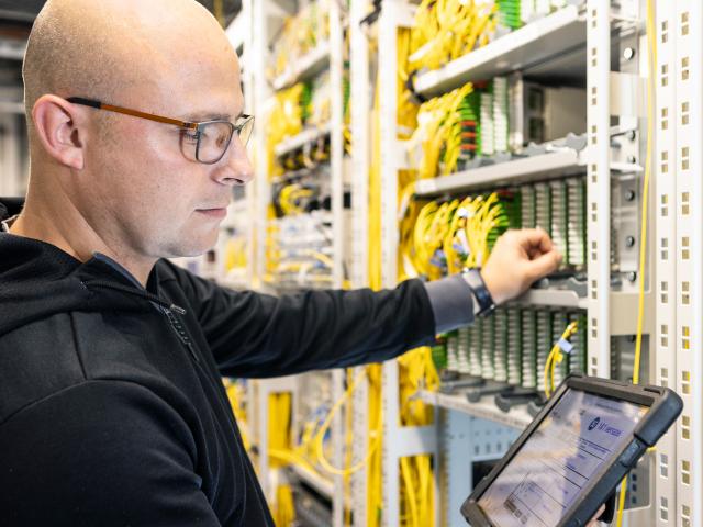 Foto: Servicetechniker prüft Lichtdurchlässigkeit der Glasfaser-Steckverbindungen im Rechenzentrum