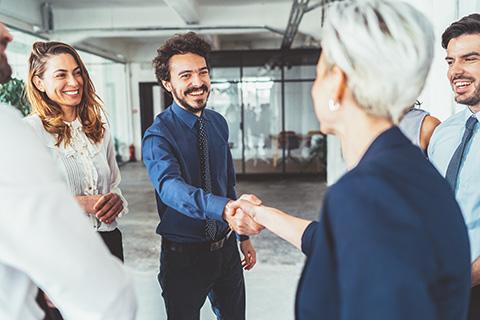 Zwei Menschen geben sich die Hand.